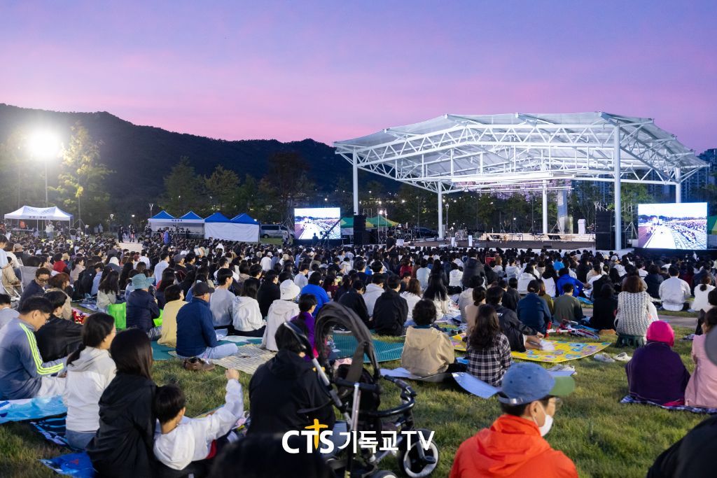 노을 아래 야외무대와 회중